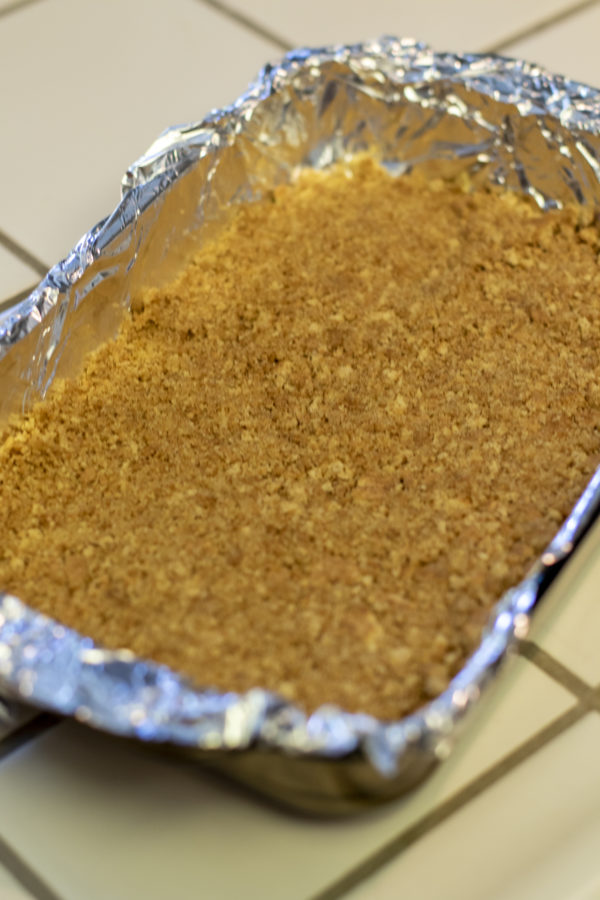 cheesecake1 pumpkin cheesecake crust in a cooking pan with foil lining.