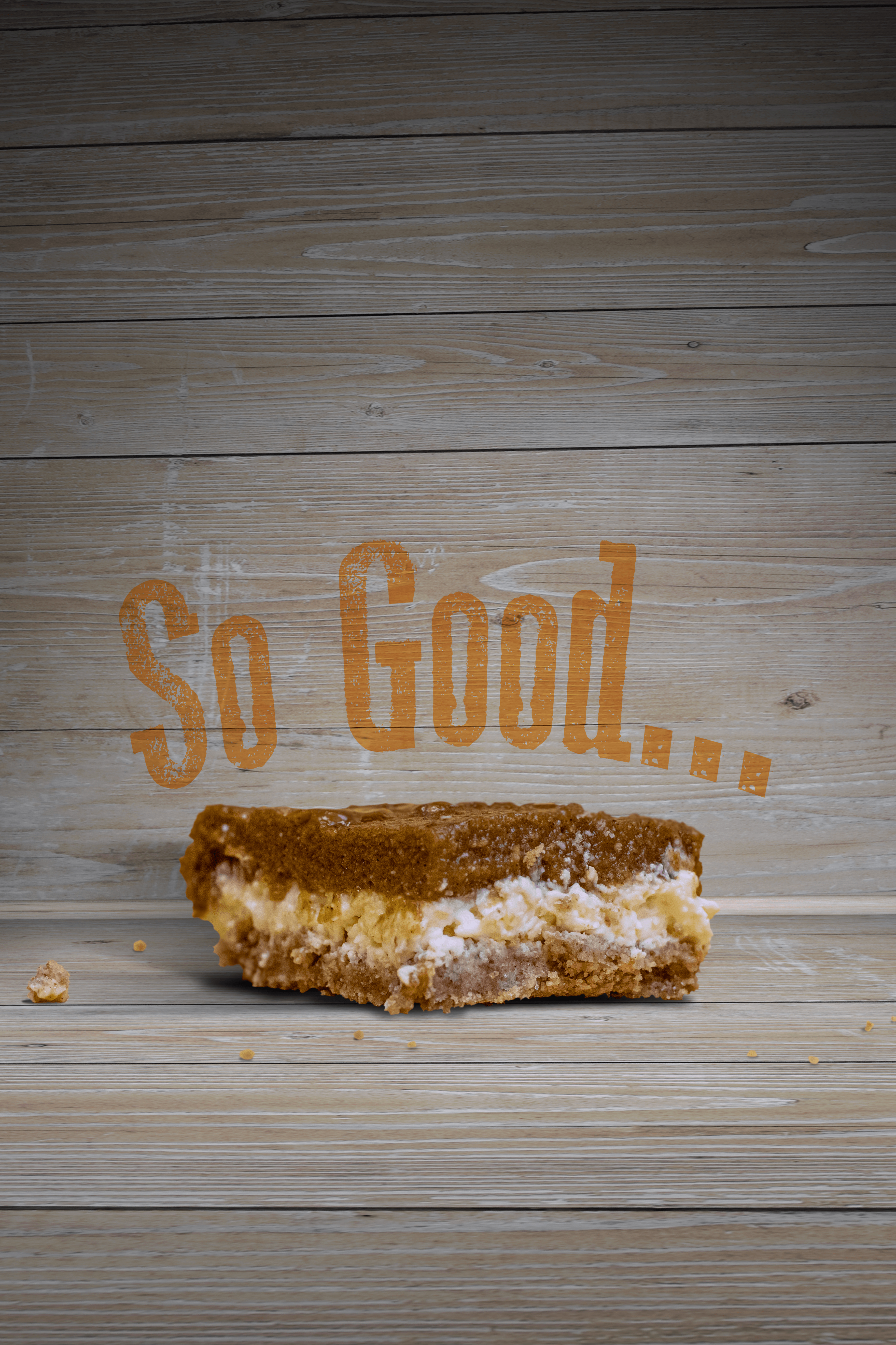 Pumpkin Cheesecake Bar with a wood backdrop behind it. Words on the wall say, "So Good..."